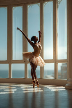 African American ballerina performing an elegant dance pose in a sunlit studio with large windows, showcasing grace and beauty in a serene environment