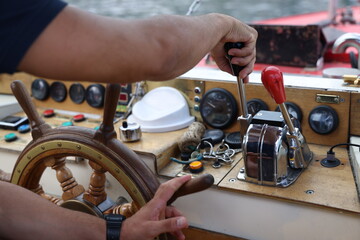 Main d’un pilote actionnant les commandes d’un bateau près du gouvernail © Bovek Photography