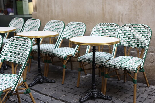 Terrasse de caf&eacute; vide avec chaises tress&eacute;es vertes et blanches