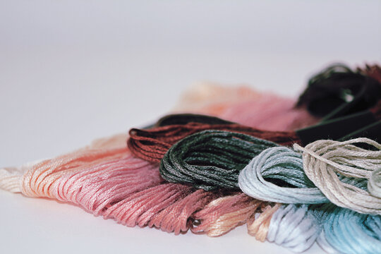 Close up of colorful embroidery thread skeins on a clean white background for needlework