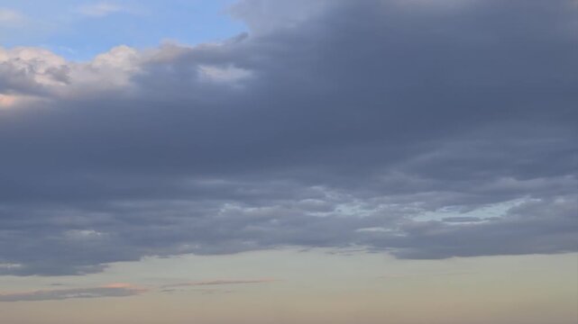 Dark clouds moving across the sky at sunset