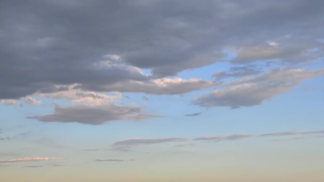 Gloomy grey clouds drifting across the sky at sunset