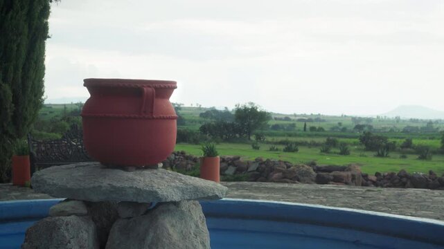 Historic colonial ruins and stone wall at entrance of Mision La Muralla under overcast sky, green landscape surrounding 18th century Mexican hacienda heritage site in Amealco Queretaro