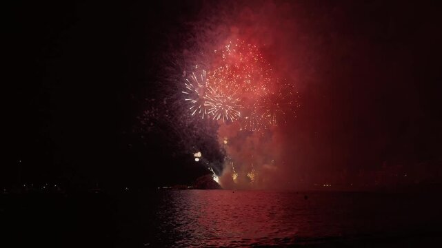 Fireworks finale glowing over sa Palomera rock in Blanes, Spain