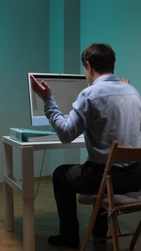Vertical video stressed businessman working on a computer and having a technical problem, showing anger and frustration with the system failure during office hours