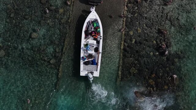 Top down aerial of a boat being launched into the ocean at Ensenada de los Muertos, Mexico.
