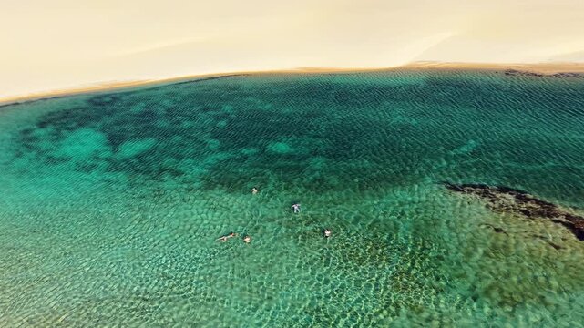 Aerial drone view of a shallow turquoise lagoon between white dunes, Lencois Maranhenses, Brazil