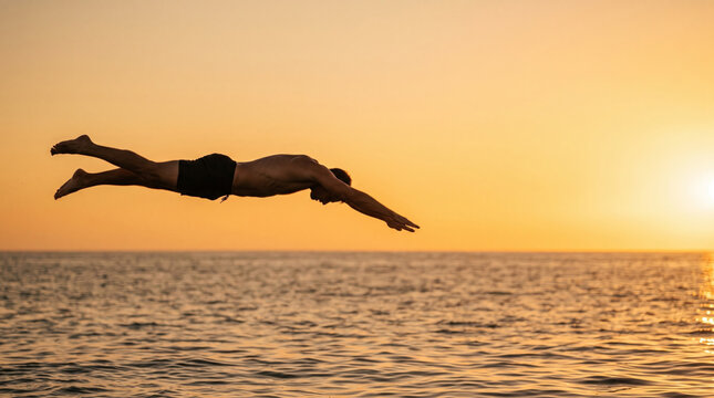 Man dives into ocean at sunset with warm golden sky and shimmering water