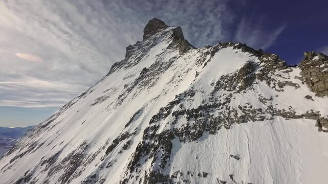 Close Aerial View of a Steep Snow Covered Rocky Mountain PeakClose Aerial View of a Steep Snow Covered Rocky Mountain Peak