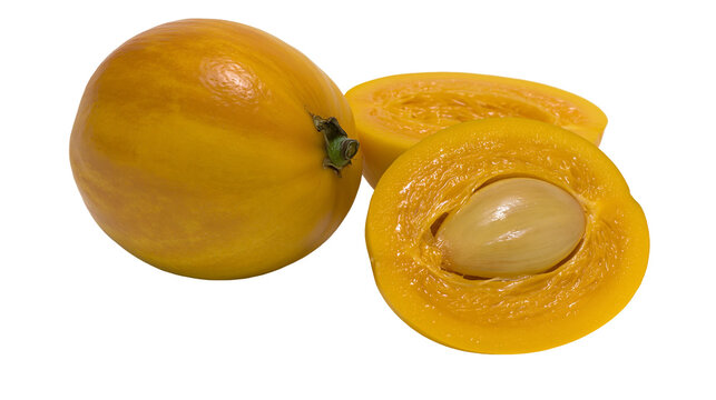 Isolated fresh lucuma fruit, whole and cut halves revealing sweet vibrant yellow pulp and large seed