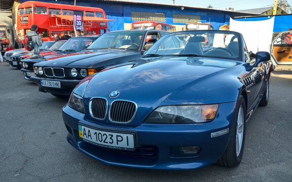Deep blue BMW Z3 Roadster convertible featuring long hood proportions, iconic kidney grille, side fender gills, and 1990s open top sports car design