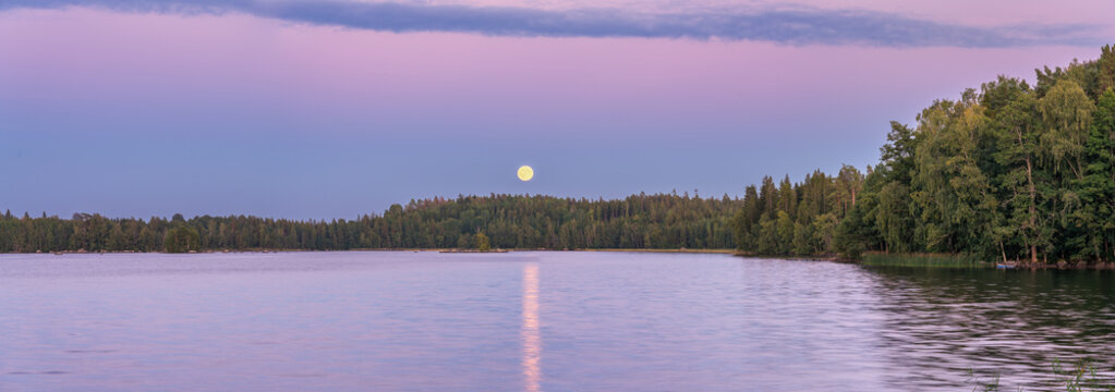 Hallangen lake at sunset with moonrise. Kalmar region. Sweden