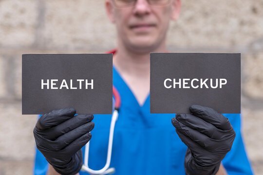 Doctor holding black cards sees the text HEALTH CHECKUP. Concept of health checkup. Medical check-up. Patient health exam.