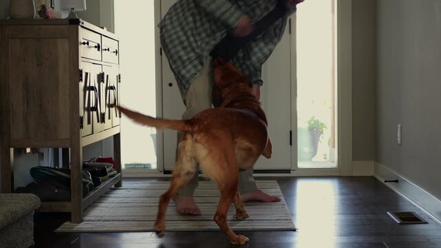 Middle-aged man bonding, hugging, and petting his rescue dog at home, showing genuine pet companionship, affection, and everyday domestic life