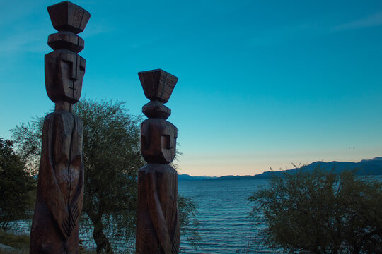 Totem wooden sculptures at sunset in the lake shore, Bariloche, Patagonia, Argentina