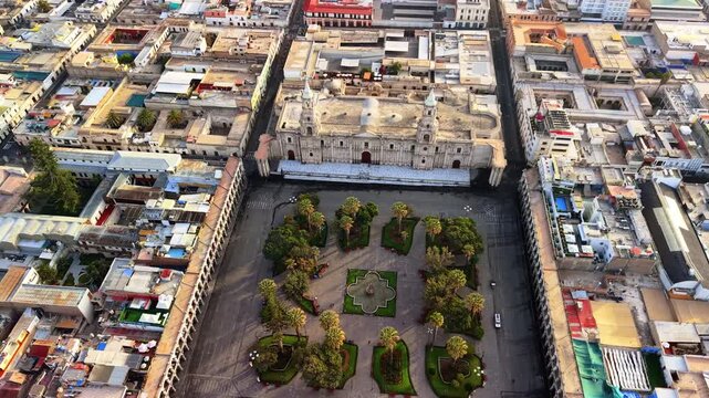 Overhead aerial drone view of the Basilica Cathedral, the palm trees and the fountain of the Plaza de Armas, Arequipa, Peru