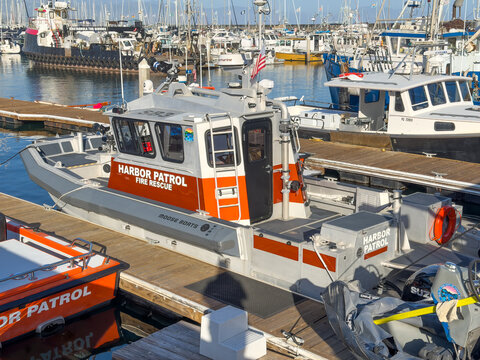 SANTA BARBARA, CA, APR 8, 2026: Gray, white and orange Harbor Patrol Fire Rescue vessel docked in a crowded working marina full of fishing boats and equipment