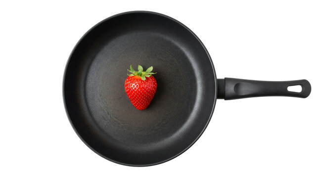 Um morango fresco e maduro colocado no centro de uma frigideira preta vazia, isolado sobre um fundo branco, vista superior minimalista para culin&aacute;ria e gastronomia.