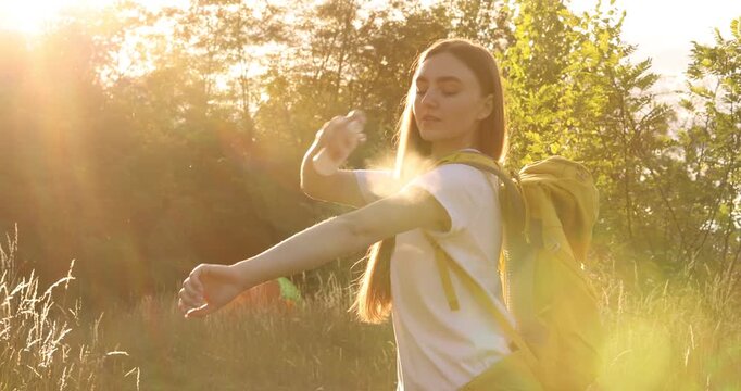 Woman spraying insect repellent onto her arm outdoors
