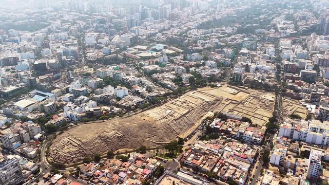 Aerial drone view of the ancient adobe pyramid of Huaca Pucllana with the Miraflores skyline behind, Lima, Peru