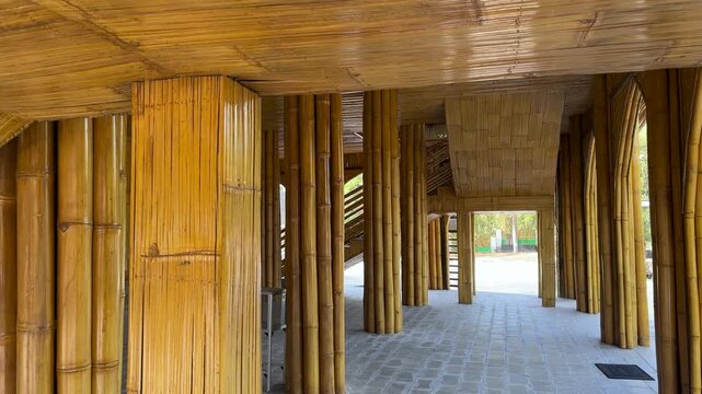 Bamboo columns support a decorative outdoor walkway structure in rural