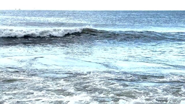Looking out from the beach at the waves in the ocean.