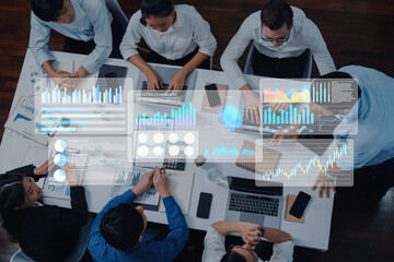 A diverse business team collaborates in a modern office, utilizing digital interfaces and charts to...
