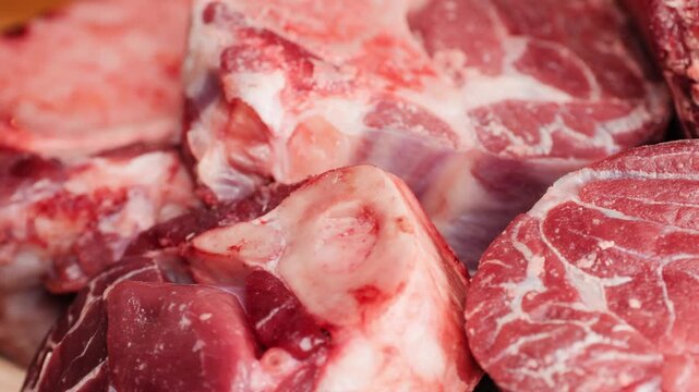 Fresh beef ossobuco steak with salt, spices and herbs on textured background, bones. 