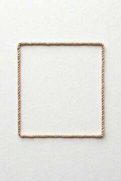 A Simple Square Frame Crafted from Light Brown Twine on a Smooth White Surface, Ideal for Text or Image Placement