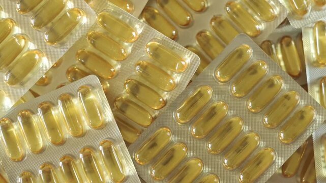 Close-up view of omega-3 capsules in blister packs, highlighting their glossy appearance and orderly layout against a light backdrop