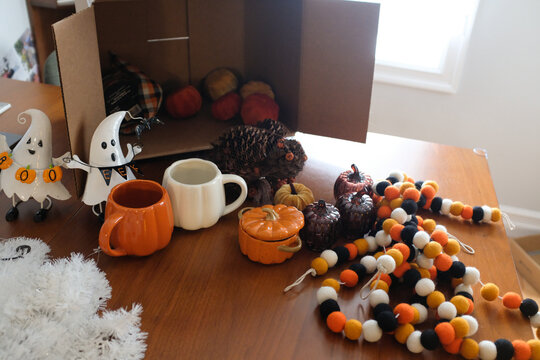 Brown cardboard storage box with halloween decorations ready to decorate on kitchen table.