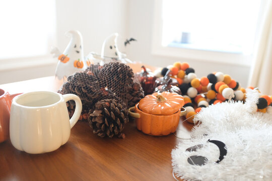 Halloween decorations ready to decorate on kitchen table, ghosts, pinecones, pumpkins and garland