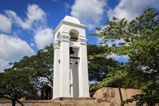 White Bell Tower and Green Trees Against Blue Sky with Clouds, Galle, Sri Lanka
