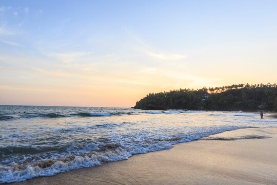 Tropical Beach Sunset Over Ocean Waves and Sandy Shore