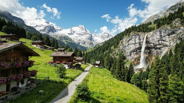 Swiss alps landscape with traditional wooden chalets, lush green meadows, and waterfall in summer switzerland