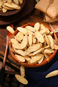 Dried slices of astragalus root in a wooden spoon and basket,traditional Chinese medicine