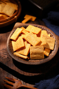 Crispy savory fried rice cracker chips in a rustic wooden bowl
