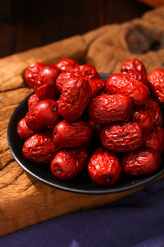 Fresh red jujubes on a black plate