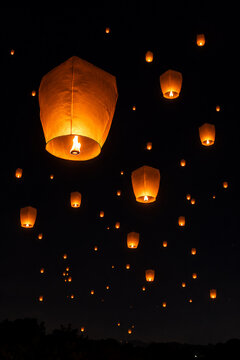 Flying fire lanterns in the dark night sky.