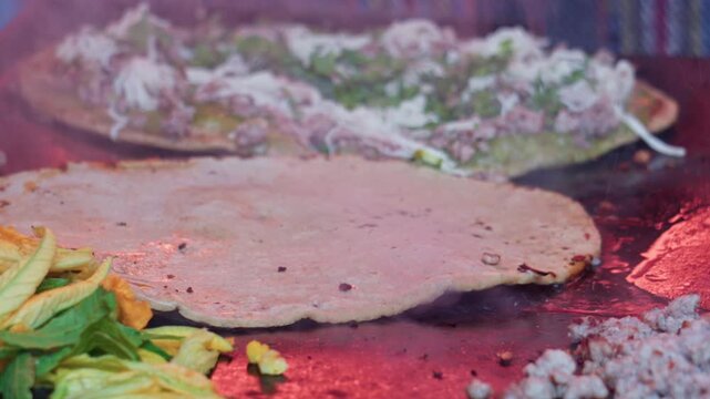 Mexican street food memelas cooking on griddle
