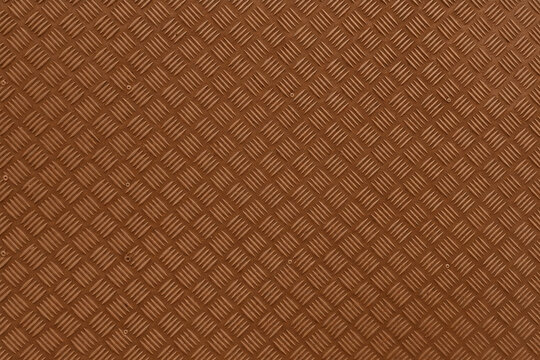 Brown metal texture with a raised diamond plate pattern and warm industrial finish. Durable steel surface ideal for flooring, stairs, panels, machinery, construction, and architectural backgrounds.