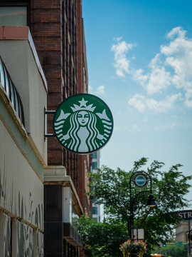 ROCKFORD, IL - SEPT 3, 2026: The iconic Starbucks sign projecting outward from a building facade at the intersection of State and Main streets downtown.