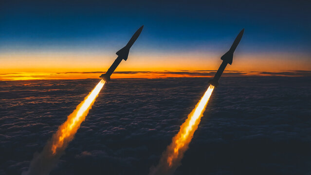 Two rockets launching with fire trails over thick clouds at sunrise