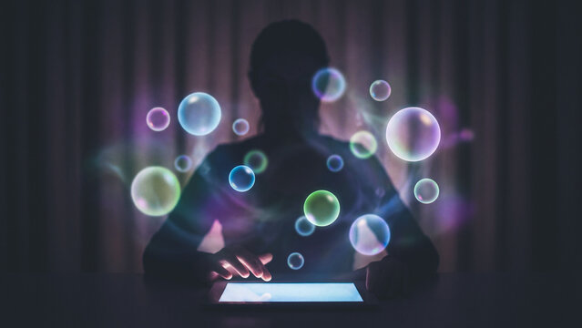 Individual using technology on a tablet creating futuristic bubbles