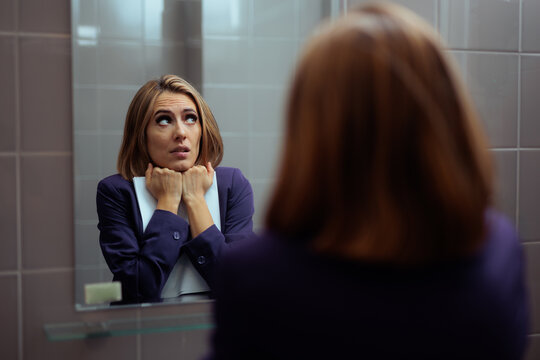 Anxious Businesswoman Holding Clipboard Rehearsing Speech In Front Of Mirror. Nervous female corporate worker practicing presentation reflection while experiencing sudden immense stage fright pressure