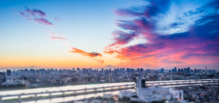 Aerial view of tokyo tower, Mount Fuji and city skyline with skyscrapers and blurred foreground at sunset in Japan, miniature tilt shift effect