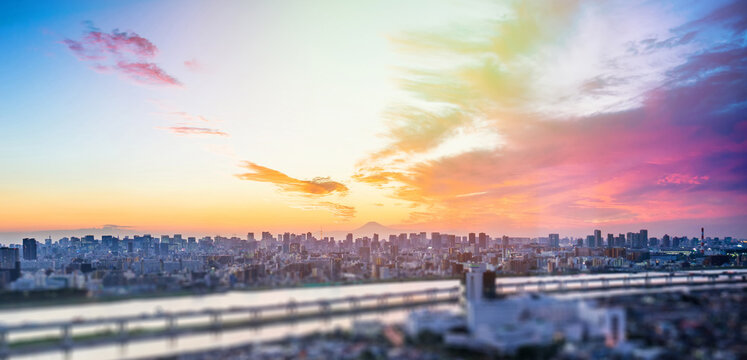 Aerial view of tokyo tower, Mount Fuji and city skyline with skyscrapers and blurred foreground at sunset in Japan, miniature tilt shift effect