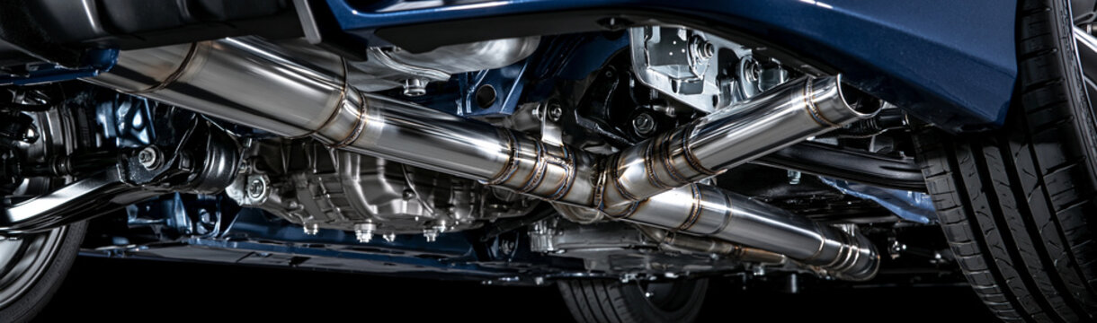 Performance Exhaust System: A detailed close-up view of a shiny, polished metal performance exhaust system on a vehicle, showcasing intricate piping and muffler assembly.