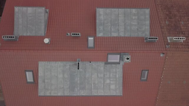 Drone rises above a house roof with dormers chimneys street and full property layout.