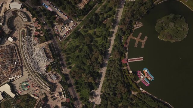 Slow ascending drone view over Chapultepec Forest, showing part of the lake, Parque Aztl&aacute;n, people, and abundant vegetation in Mexico City.